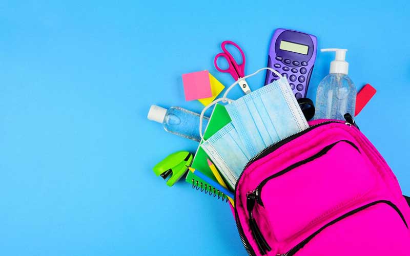 a pink backpack filled with school supplies on a blue background.